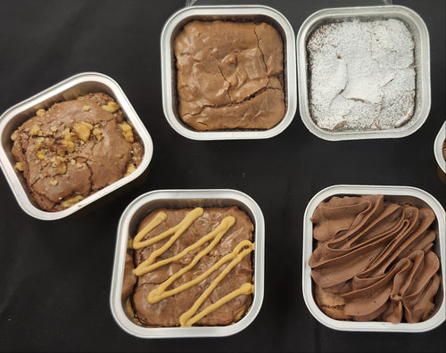 Assorted brownies in tins on black background